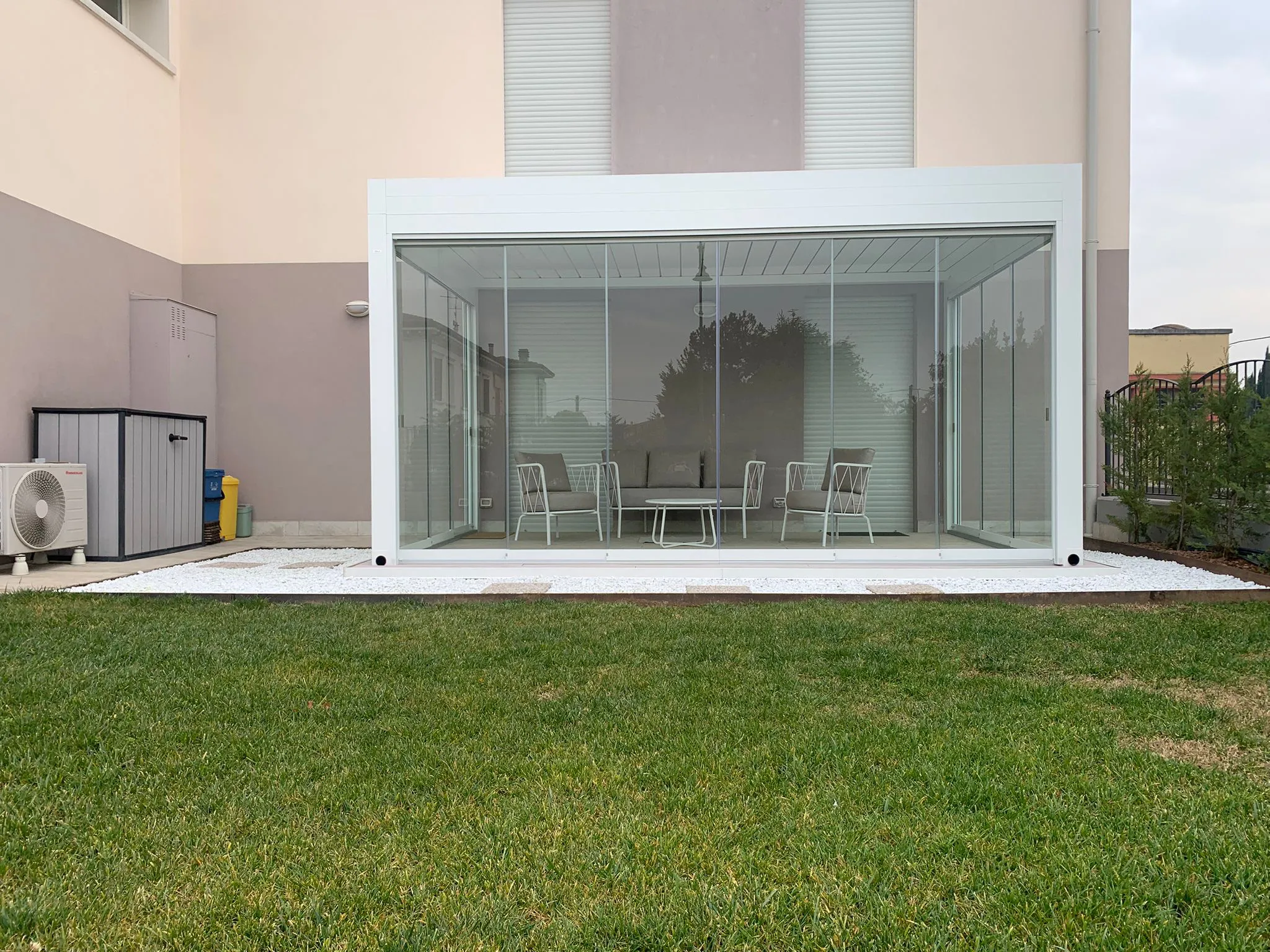 Pergola bioclimatica con chiusure vetrate e tende filtranti